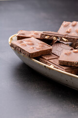 Chocolate cupcake with icing and chocolate bar in Dark lighting,Homemade delicious chocolate muffin on wooden background close-up