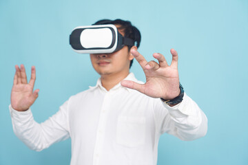 Isolated man wearing VR headset and white shirt, click hand gesture, interacting with a virtual environment on light blue background