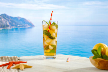 Tropical cocktail on the beach. Seascape background and copy space for products.