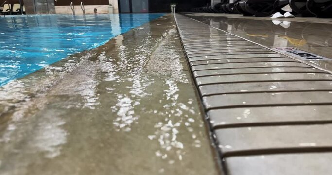 Large body of water with a blue tile floor in swimming pool with thermal water