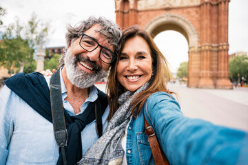Married couple taking selfie in front of Triumphal Arch in Barcelona, Catalonia, Spain - Husband...