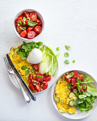 Mozzarella Bufala, omelet with zucchini, salad with tomatoes and basil, assorted lettuce leaves, delicious wonderful summer lunch. A balanced diet with fats, proteins and fiber. Mediterranean diet