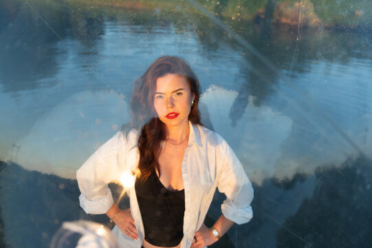 Water ball (similar to zorb or Human Hamster Ball) with young woman inside on pond surface