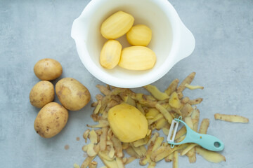 Peeled potatoes on the table and in the bowl.
