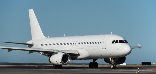 White plane to runway for take off, airplane taxiing for take off. White passenger jet plane taxiing along the runway in the airport