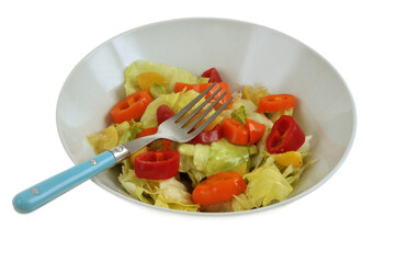 Salade composée maison avec de la iceberg et des rondelles de petits poivrons servie dans un saladier avec une fourchette sur fond blanc