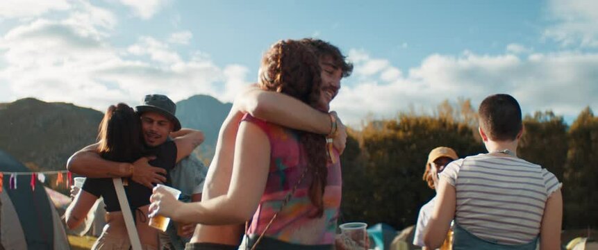 Friends hugging and having fun at a music festival. Captured using an anamorphic lens and presented in the 2.39:1 CinemaScope aspect ratio.