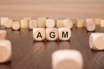 AGM text 'Annual General Meeting' wooden cube blocks on table background. business target and focus concepts