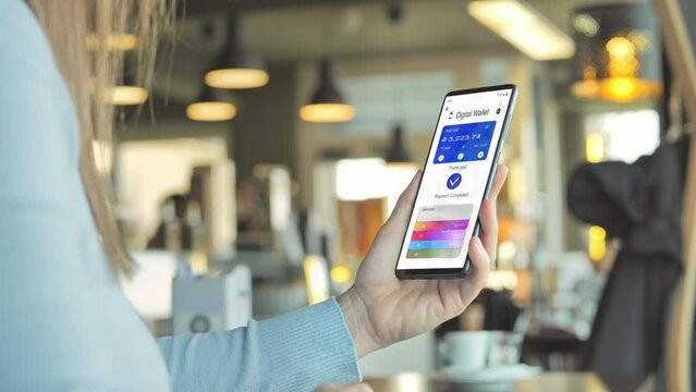 woman at cafe using smart phone digital wallet to pay online,back view of caucasian female shopping on internet web store paying with wireless credit card,secure payment - Powered by Adobe