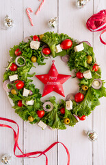 Close-up of the Christmas wreath salad with vegetables and feta cheese on the dark background. Selective focus