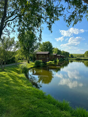 Fototapeta premium Discover the perfect fishing spot on our serene lake. Enjoy tranquil surroundings, clear waters, and the thrill of the catch. Ideal for a relaxing day in nature with friends and family.