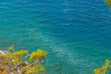 Beautiful view from above from the cliff to the clear turquoise sea on a sunny summer day. Concept of nature, travel, outdoor activities