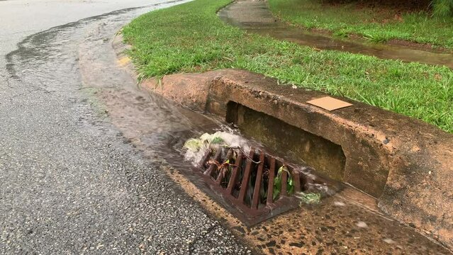 A storm drain or stormwater drain or stream of rainwater on a Wilmington street after heavy rain. Delaware.