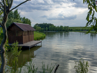 Obraz premium Discover the perfect fishing spot on our serene lake. Enjoy tranquil surroundings, clear waters, and the thrill of the catch. Ideal for a relaxing day in nature with friends and family.
