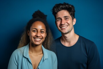 Obraz premium Smiling portrait of a young interracial couple on colorful background