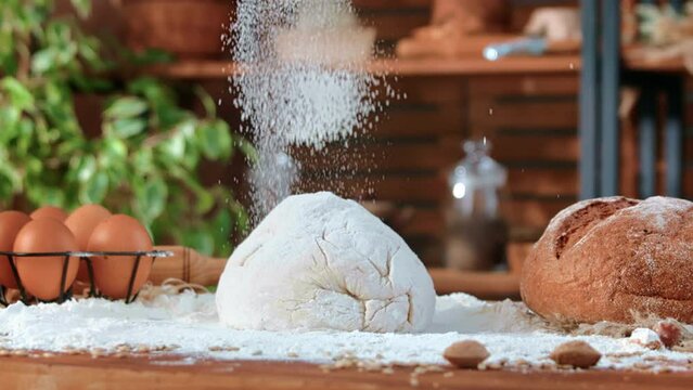 Kitchen of traditional bakery, fresh dough on table, organic flour pouring, traditional recipe.