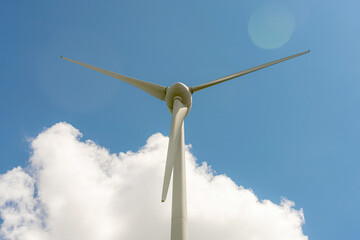 Wind power generator against a cloudy sky.