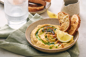 Delicious homemade hummus with lemon, paprika, olive oil and microgreens. Vegetarian Middle Eastern dish