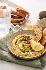 Delicious homemade hummus with lemon, paprika, olive oil and microgreens. Vegetarian Middle Eastern dish