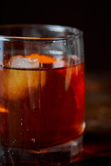 Alcoholic cocktail Negroni or non-alcoholic cocktail, drink with ice and orange peel as decoration on wooden table