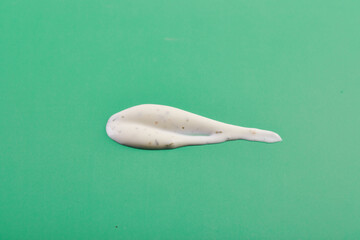 Ranch sauce, texture with drops on green background