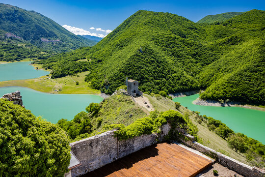 A view of Lake Turano from Mount Antuni, in the village of Castel di Tora, Rieti, Lazio, Italy. The small hermitage above the lake, surrounded by green mountains. Blue sky in summer.