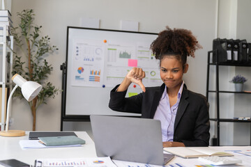 happy young businesswoman African American siting on the chiar cheerful demeanor raise holding coffee cup smiling looking laptop screen.Making opportunities female working successful in the office.	