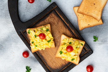 Healthy vegetarian breakfast . Scrambled eggs toast with cherry tomatoes and parsley