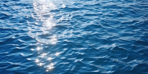 Fototapeta premium Sun Glints on Rippling Blue Water, sparkling sunlight reflecting on the deep blue sea