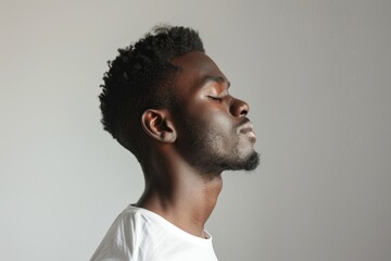 Obraz premium African American man standing peacefully with eyes closed.