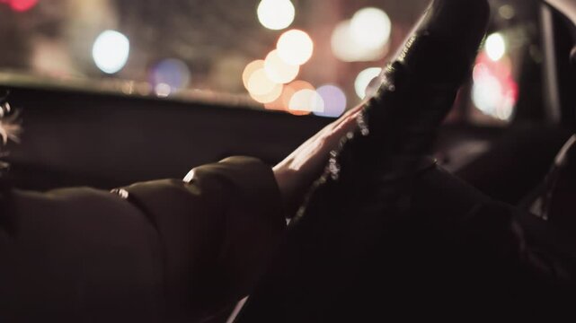 First-person view of a hand hitting the horn of a car at night. The scene features blurred city lights in the background