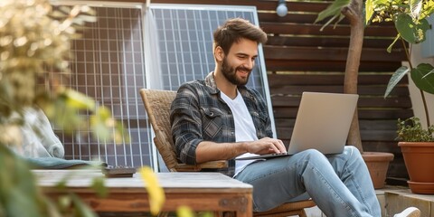 A smiling freelancer works on a laptop in a yard, embodying modern business and sustainable housing.