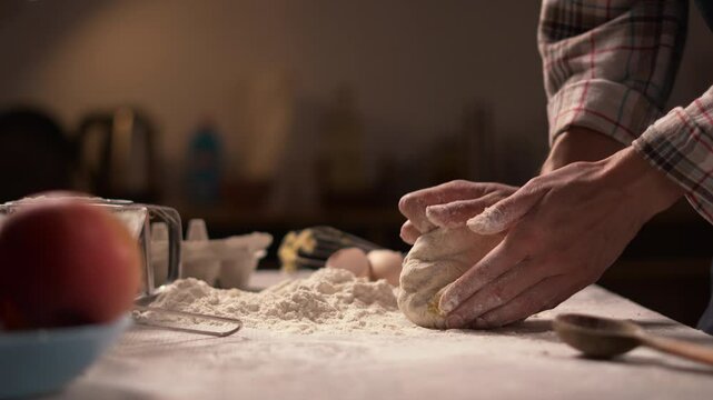 Close-up of woman's hands kneading dough on a floured surface. The scene, set in a cozy kitchen, captures the traditional and tactile aspects of preparing homemade bread, highlighting the warmth and