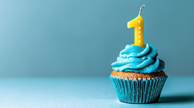 A blue cupcake with a number one candle on it sits on a blue background.