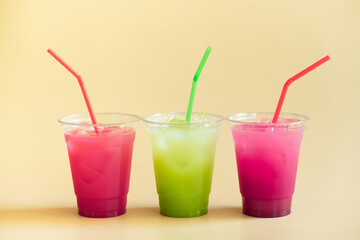 Colored summer lemonades on beige background