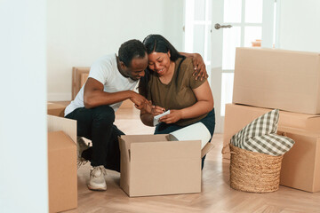 Making notes into notepad. African American couple are moving into new house