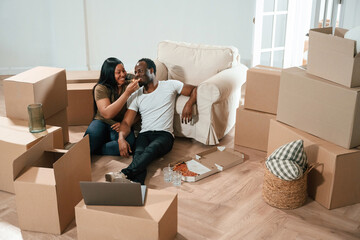Conception of celebration, eating pizza. African American couple are moving into new house
