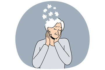 Elderly woman suffers from dementia and memory loss and is in need of specialized caregivers. Sad female pensioner is sick with dementia due to advancing age or lot of psychological stress in youth