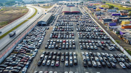 Visão aérea de um estacionamento com vários veículos estacionados, mostrando a organização e a distribuição dos carros em diferentes áreas do espaço