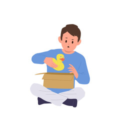 Surprised boy child cartoon character carrying rubber duck toy after cardboard box unpacking