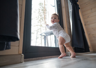 Baby boy standing by the patio window. 
