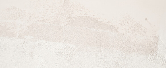 White wall background. A close-up shot of a white textured wall surface, showing a slightly grainy and uneven pattern.