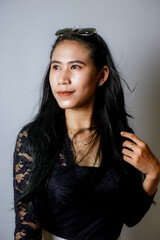 Fototapeta premium portrait of an Indonesian woman wearing a black kebaya in the studio with a disheveled pose isolated white background