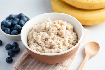 Cooked oatmeal porridge in bowl, healthy breakfast rich in fiber