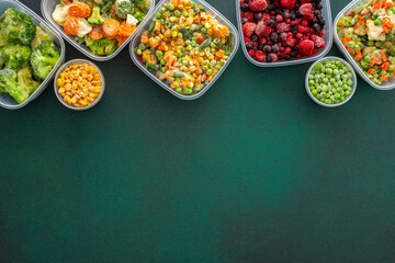 Food in winter, freezing fresh vegetables in summer in the refrigerator, various frozen vegetables in plastic dishes on a green background, top view