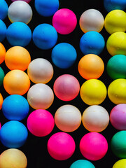 Top view of many colorful plastic balls on water. View of colored sponge balls. Many colorful balls as background. Lots of colorful balls for children to play in the water park. Toy pool for kids.