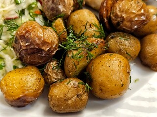 Young, small, whole fried potatoes. Golden fried. With garlic and greens.