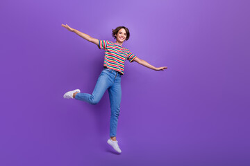 Full length photo of cheerful carefree girl wear trendy clothes open hands flying air empty space isolated on violet color background