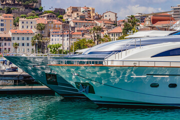 Luxury yachts are peacefully anchored in a beautiful Mediterranean harbor with picturesque views....