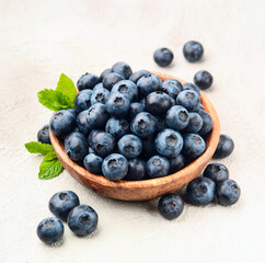 Blueberries with mint in wooden plate